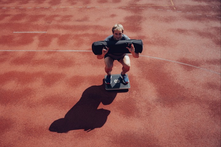Athlete balancing on a board with a sandbag, photographed from above on the track